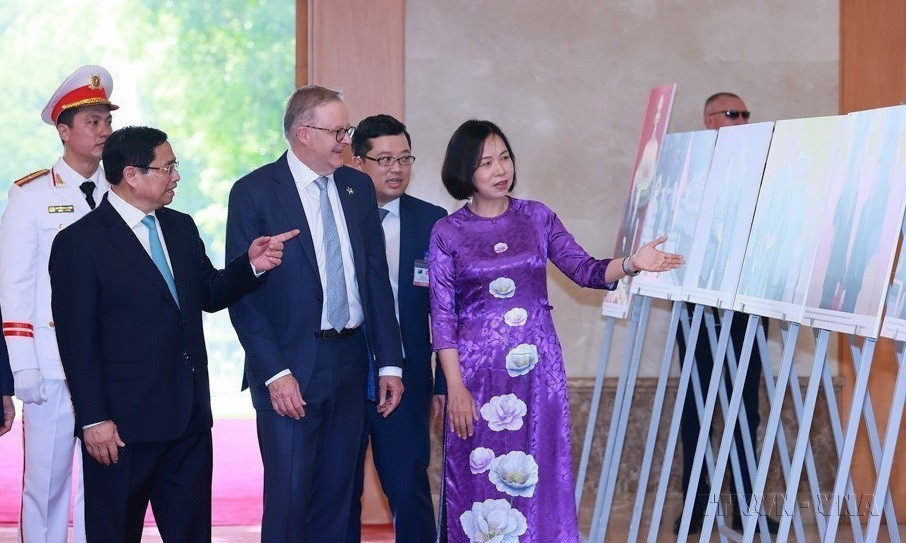 Генеральный директор ВИА Ву Вьет Чанг представляет премьер-министру Фам Минь Тьиню и премьер-министру Австралии Энтони Альбанезе фотовыставку об отношениях сотрудничества между Вьетнамом и Австралией, организованную ВИА 4 июня 2023 г. (Фото: ВИА)