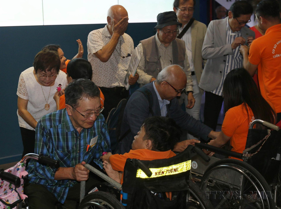 Дети в деревне для сирот «Хоабинь», жертвы Агента Оранж/диоксин, вручают сувениры японским делегатам, присутствовавшим на фотовыставке, посвященной жертвам войны в Японии и Вьетнаме. (Фото: ВИА)