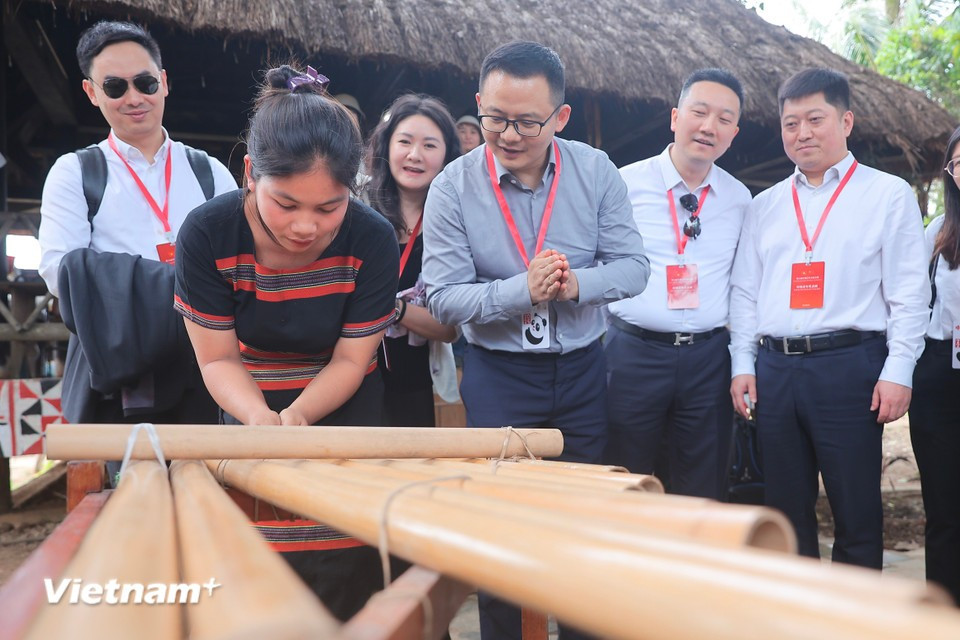 Туристы знакомятся со способом игры на инструменте клонгпут народа Cоданг — музыкальном инструменте ряда народностей Центрального нагорья. (Фото: Vietnam+)