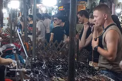 Иностранные туристы с удовольствием покупают сувениры на ночном рынке Старого квартала Ханоя. Фото: ВИА.