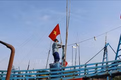 Рыбаки поднимают Государственный флаг перед выходом в море, подтверждая суверенитет страны над морскими и островными территориями.