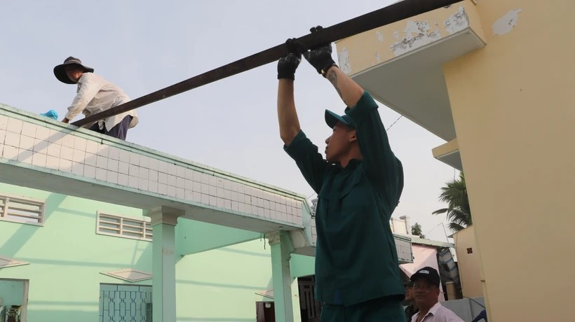 Вооруженные силы поселка Лонгми помогают жителям сносить временные и ветхие дома (Фото: ВИА)