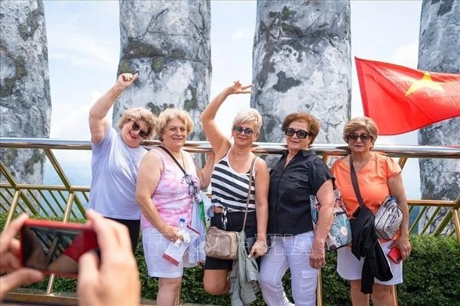 Иностранные туристы с удовольствием делают фото на Золотом мосту в Дананге (Фото: ВИА)
