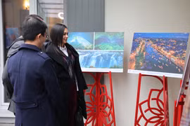 Международные друзья осматривают фотографии на выставке. Фото: ВИА.