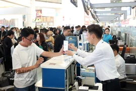 Пассажиры проходят регистрацию в зале внутренних вылетов аэропорта Нойбай в последний день каникул по случаю Тэт Бинь Нго — 22 февраля. Фото: ВИА.