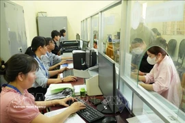 Государственные служащие в коммуне Тхайми (город Хошимин) рассматривают административные документы для граждан. Фото: ВИА.