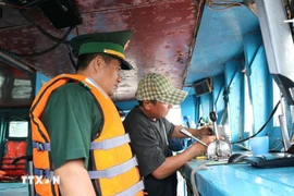 Боец пограничного поста Лонгвинь проверяет оборудование на рыболовном судне в рыболовном порту Диньан (коммуна Дайан, провинция Виньлонг). Фото: ВИА.