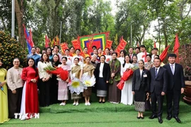 Супруга Нго Фыонг Ли и супруга Нали Сисулит вручают цветы студентам Университета Хоалы. Фото: ВИА.