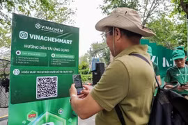 Мужчина сканирует QR-код платформы электронной коммерции VinachemMart во время запуска 10 мая. (Фото: ВИA)