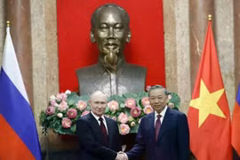 Генеральный секретарь ЦК КПВ То Лам (справа) позирует для фото с президентом России Владимиром Путиным (Фото: ВИA)