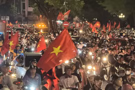  Люди выходят на улицы Ханоя, размахивая национальным флагом в знак празднования победы. (Фото: ВИA) 