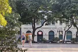 Иностранные туристы прогуливаются под кронами деревьев вдоль озера Хоанкием, наслаждаясь прохладной осенней погодой Ханоя. (Фото: ВИА)
