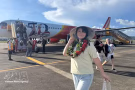 Пассажир фотографируется рядом с самолётом Vietjet. Фото: ВИА. 