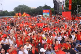 Толпа жителей в красных флагах с желтыми звездами заполняет перекресток Хынг Выонг – Чан Фу в ожидании второй полной репетиции (Фото: ВИA)