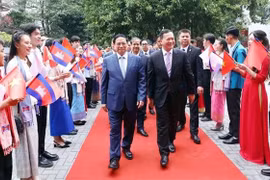 Премьер-министр Фам Минь Тьинь и премьер-министр Камбоджи Самдек Моха Борвор Тхипадей Хун Мане посещают Университет внешней торговли в Ханое 12 декабря (Фото: ВИA)