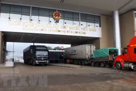 Грузовики пересекают международные пограничные ворота Кимтхань №2. (Фото: ВИА)