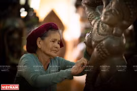 80-летняя мастер Чыонг Тхи Гать заканчивает создание танцовщицы апсары. (Фото: VNP/ВИА) 