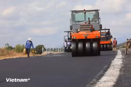 Подрядчики выполняют работы по укладке асфальтобетонного покрытия дороги проекта Северо-Южной скоростной автомагистрали в восточной части. (Фото: Вьет Хунг/Vietnam+)