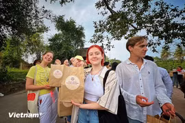 Иностранным туристам нравится как знакомиться с вьетнамскими туристическими направлениями, так и получать сувениры. (Фото: Май Май/ Vietnam+)