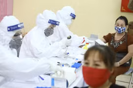 Медицинские работники собирают образцы у мелких торговцев на рынке Лонгбьен в Ханое для проведения экспресс-тестов (Фото: ВИА) 