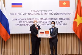 Заместитель министра иностранных дел То Ань Зунг (справа) передает товарную помощь послу России Константину Внукову (Фото: ВИA)