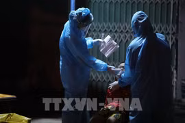 Медперсонал берет пробы для тестирования на коронавирус у ребенка в квартале Виньхынг, район Хоангмай, Ханой, вечером 19 сентября. (Фото: ВИА)