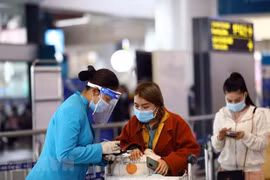 Персонал Vietnam Airlines помогает пассажирам с процедурой электронного декларирования здоровья. (Фото: ВИА)