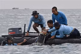 Водолазы из военно-морских сил ищут обломки самолета, разбившегося в водах недалеко от острова Ланканг, Индонезия, 10 января. (Фото: AFP /ВИА)