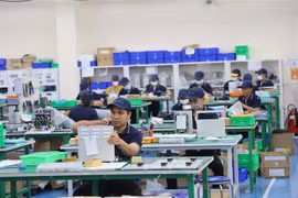 Рабочие собирают промышленное роботизированное оборудование на заводе Tazmo Vietnam — компания, на 100% принадлежащая японцам. (Фото: ВИА) 