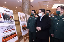 Премьер-министр Фам Минь Тьинь посещает фотовыставку по предотвращению бомб и мин. (Фото ВИА)