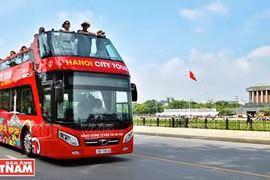 Туристы на hop-on hop-off проезжают мимо мавзолея Хо Ши Мина в Ханое. (Фото: ВИА)