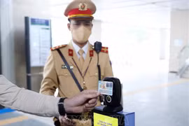 Люди используют удостоверение о личности с чипом для сканирования QR-кода на наземных железнодорожной линии Ханоя. (Фото: ВИА)