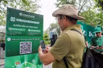Мужчина сканирует QR-код платформы электронной коммерции VinachemMart во время запуска 10 мая. (Фото: ВИA)