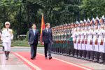 Президент государства Лыонг Кыонг (слева) и президент Франции Эммануэль Макрон обходят строй почетного караула Вьетнамской народной армии. (Фото: ВИA)