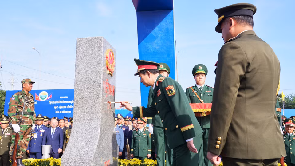Генерал армии Тиа Сеиа, заместитель премьер-министра, министр национальной обороны Королевства Камбоджа, наблюдает, как генерал армии Фан Ван Жанг, министр национальной обороны Вьетнама, наносит краску на пограничный столб №171 в международном пункте пропуска Мокбай (провинция Тэйннинь). (Фото: ВИА)