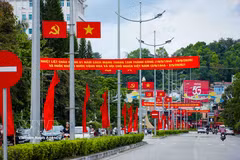 Флаги Партии, Государственный флаг, а также транспаранты и лозунги создают оживлённую праздничную атмосферу на улицах кварталов города Дьенбьенфу (Фото: ВИА)