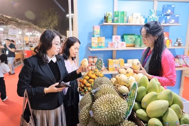 Посетители приобретают продукцию на фестивале Vietnam OCOP 2025, одном из ключевых национальных программ по продвижению торговли. (Фото: ВИА) 
