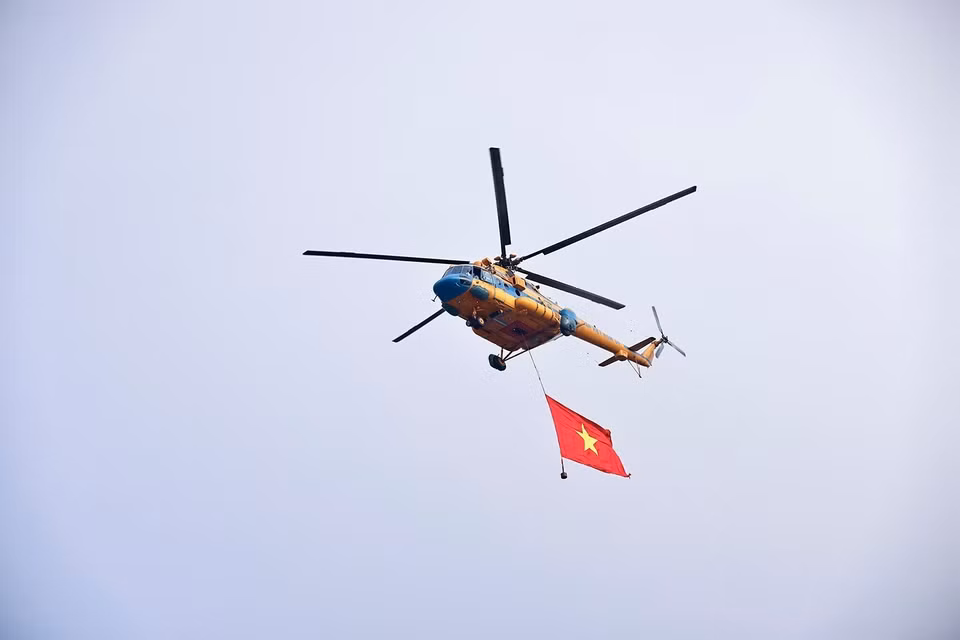 Вертолет несёт государственный флаг во время демонстрационного пролёта над площадью Бадинь. Фото: ВИА.