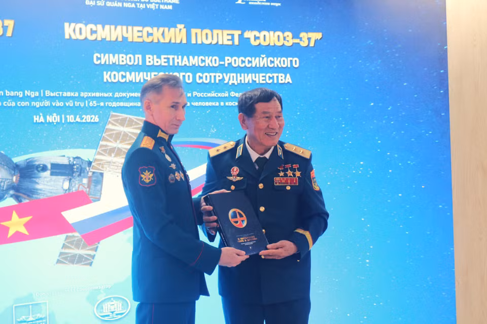 Первый космонавт Вьетнама Фам Туан принимает памятный подарок на выставке, посвящённой миссии «Союз-37» в Ханое. Фото: ВИА.