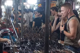 Иностранные туристы с удовольствием приобретают сувениры на ночном рынке Старого квартала Ханоя. (Фото: ВИА).