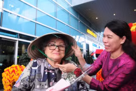 Представитель компании Anex Tour Vietnam вручает коническую шляпу первым пассажирам, прибывшим в Дананг из Владивостока. Фото: ВИА