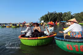 Иностранные туристы с удовольствием знакомятся с жизнью на воде, совершая прогулки на традиционных круглых корзиночных лодках в кокосовой деревне Камтхань, вошедшей в число 50 самых красивых деревень мира в 2025 году. (Фото: ВИА.)