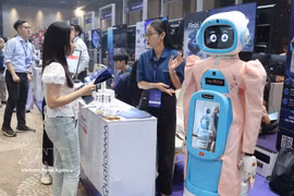 Посетители знакомятся с моделью робота по уходу за пожилыми людьми на стенде Qualcomm. Фото: ВИА.