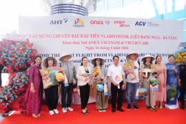 Представитель компании Anex Tour Vietnam вручает коническую шляпу первым пассажирам, прибывшим в Дананг из Владивостока. (Фото: ВИА)
