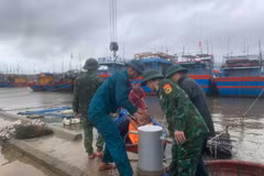 Пограничные офицеры пограничного поста порта Киха помогают жителям закреплять свои лодки. (Фото: ВИA)