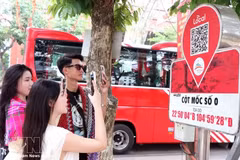 Туристы сканируют QR-коды у отметки Km0 в Хазянге, чтобы получить туристическую информацию. (Фото: ВИА) 