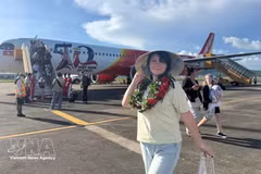 Пассажир фотографируется рядом с самолётом Vietjet. Фото: ВИА. 