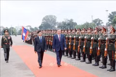 Президент Вьетнама То Лам и генеральный секретарь Народно-революционной партии Лаоса, президент Лаоса Тхонглун Сисулитх обходят почетный караул (Фото: ВИA)