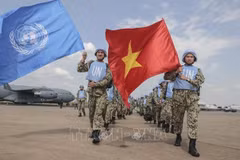 Вьетнамские военные медики поднимают два флага ООН и Вьетнама в международном аэропорту Джуба, приступая к выполнению миротворческой миссии ООН в Южном Судане. (Фото: ВИА)