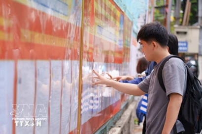 Студенты Педагогического технического университета (Данангский университет) изучают список кандидатов, вывешенный в университете. (Фото: ВИА)